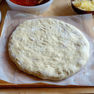 sourdough discard pizza dough rolled out on parchment