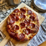 How to Make Sourdough Focaccia Pizza (Easy Recipe) 8 Sourdough focaccia pizza topped with melted cheese and pepperoni on wooden board